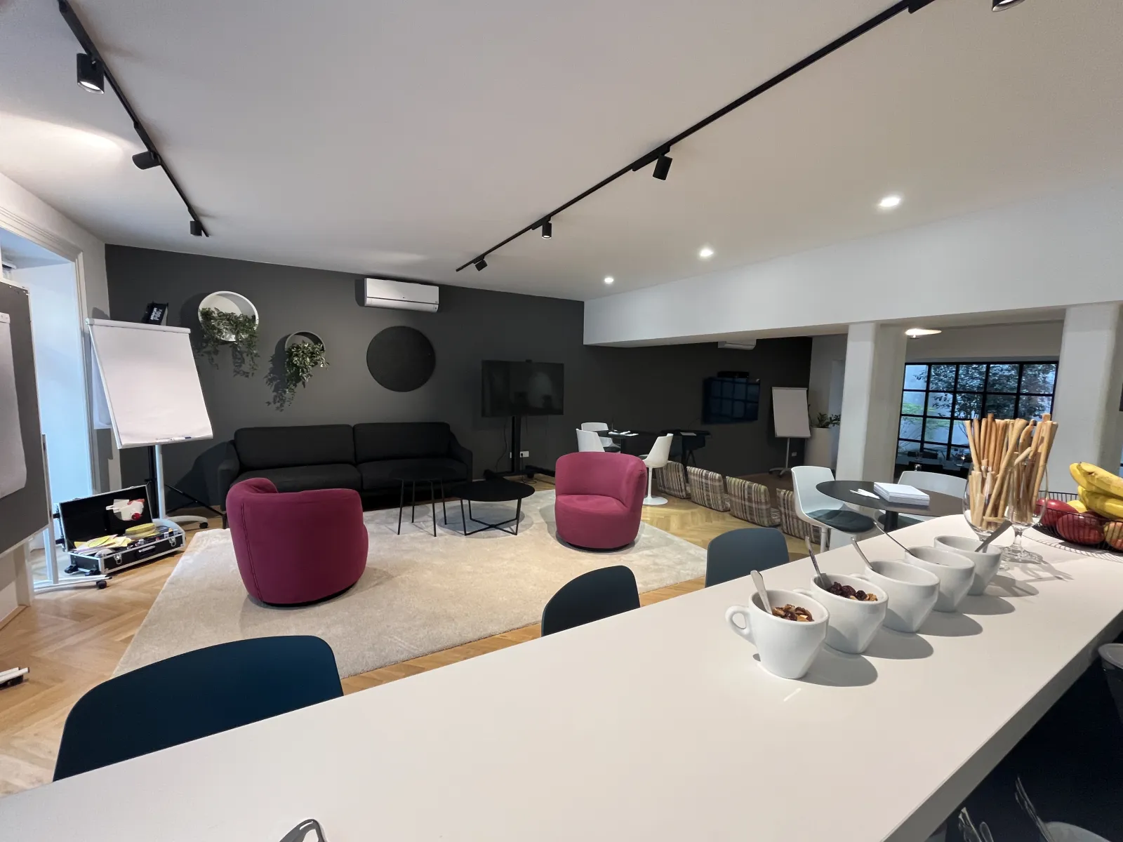 Die Lounge auf dem Hauptniveau mit Sesseln, Sofa und Blick auf die Fenster zum Innenhof